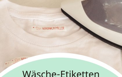 Waesche Etiketten richtig aufbuegeln ist eine Anleitung fuer Buegeletiketten. Das Foto zeigt ein weisses T-shirt. auf der Innenseite ist ein weisses Buegeletikett mit rotem Namen im Format 50 x 10 mm zu sehen. Daneben ein Buegeleisen. Dieses wird auf der Temperatureinstellung Baumwolle zum Aufbuegeln benoetigt